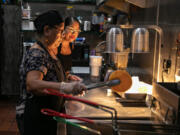 Zacil Vazquez, right, helps her mother Maria Vazquez prepare an order for a customer at their restaurant Sazon in Huntington Park, California, on Sept. 9, 2022. Just weeks before the July 1, 2024, start of a statewide ban on so-called &ldquo;hidden fees,&rdquo; state Sen. Bill Dodd, a Democrat, has proposed a new law to clarify how it applies to the restaurant industry.