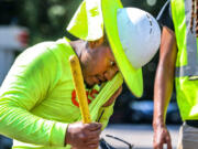 Fernando Rosales with RJH electrical contractors worked on installing an electrical box on Northside Drive near I-75 as he wiped away the sweat from the oppressive heat in metro Atlanta on Aug. 14, 2023.