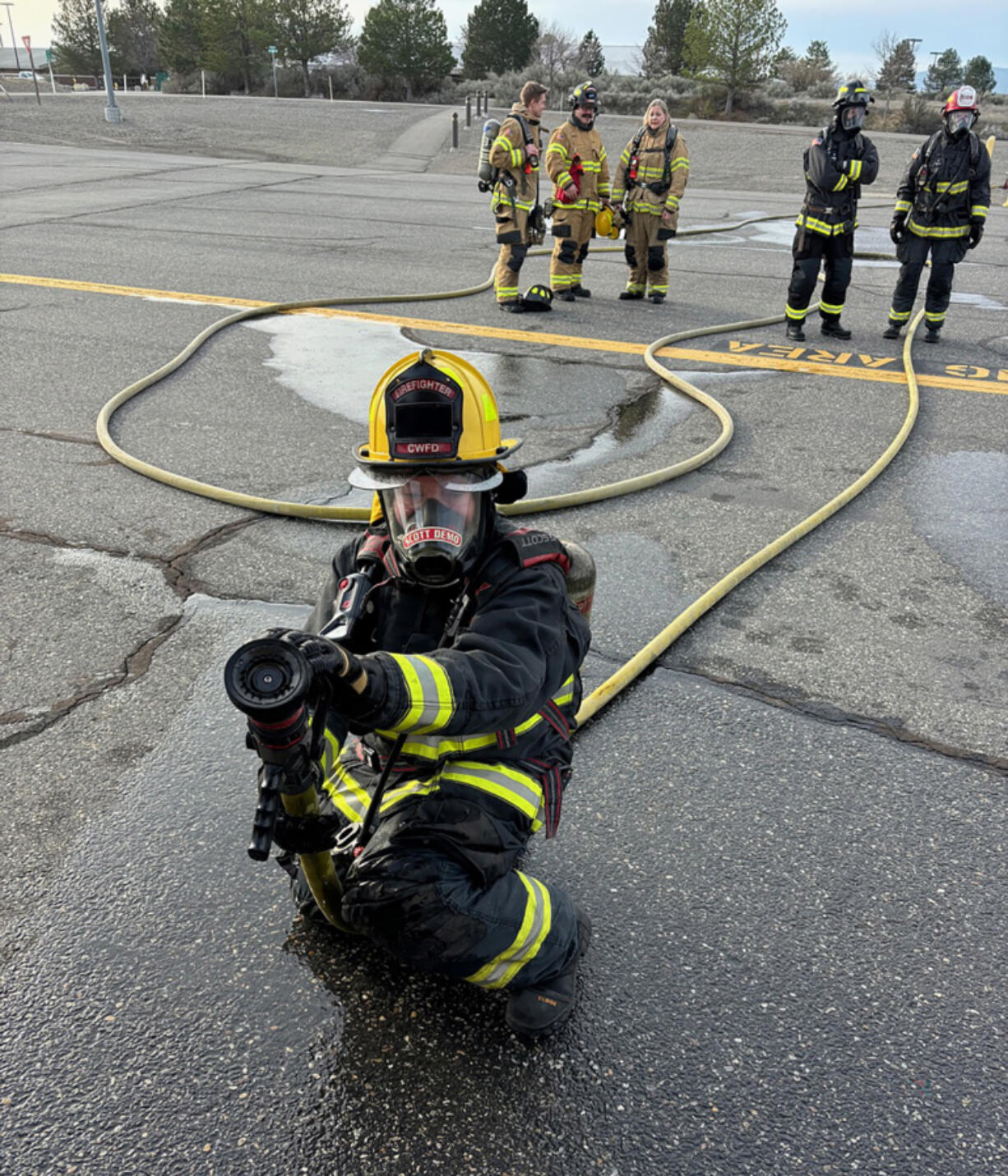 Washougal City Councilor Tia Robertson holds a firehose during the Washington State Council of Firefighters&rsquo; Fire Ops 101 event March 21 in Richland.