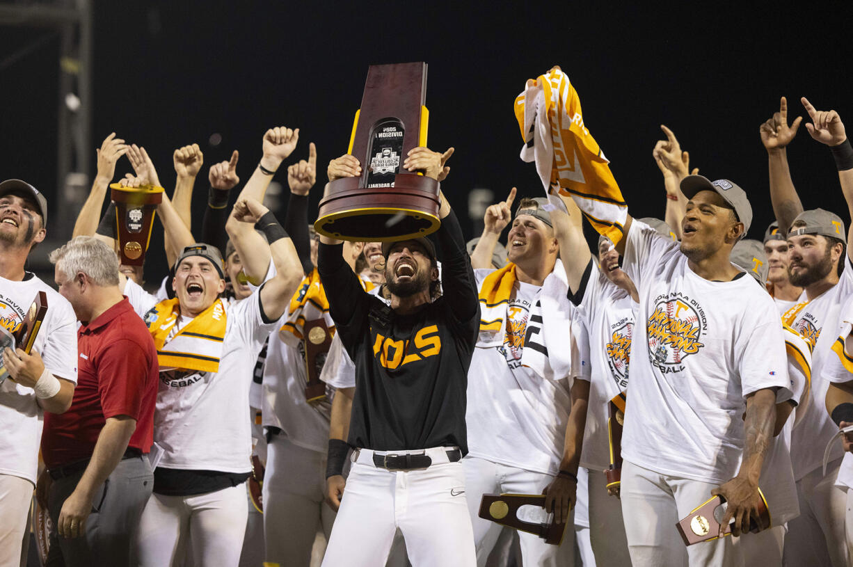 Tennessee coach Tony Vitello, center, hoists the championship trophy following his team's 6-5 victory against Texas A&amp;M in Game 3 of the NCAA College World Series baseball finals in Omaha, Neb., Monday, June 24, 2024. (AP Photo/Rebecca S.