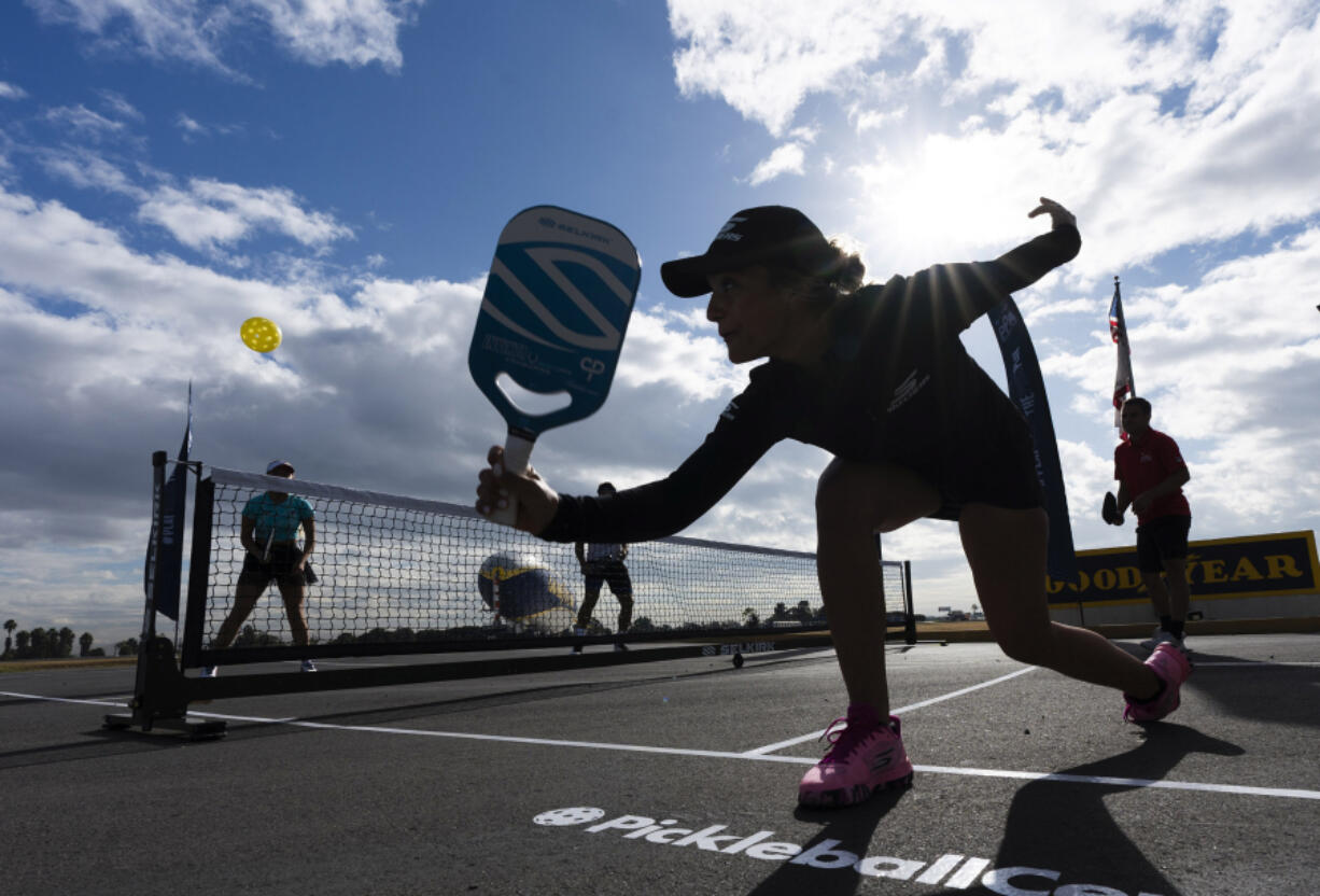 Catherine Parenteau returns the ball during a pickle ball match in Carson, Calif. The health benefits of spending time in nature have long been established, and exercise in general improves physical and mental well-being.