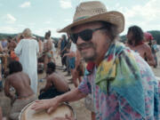 A man plays drums while others dance July 4, 2001, during The Rainbow Family Gathering in Cache Creek Meadow, Idaho.