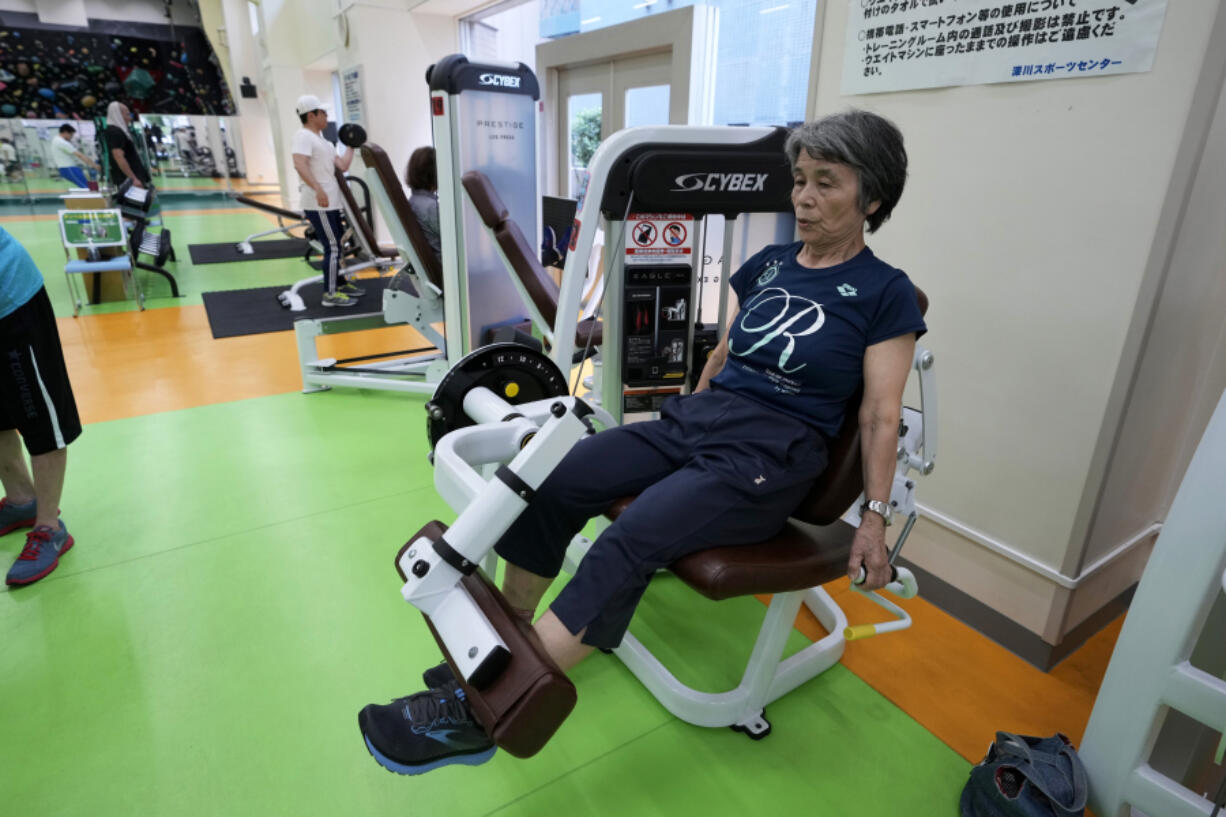 Yasuko Kuroi, 72, uses a leg extension machine as she works out June 12 at the Fukagawa Sports Center in Tokyo.