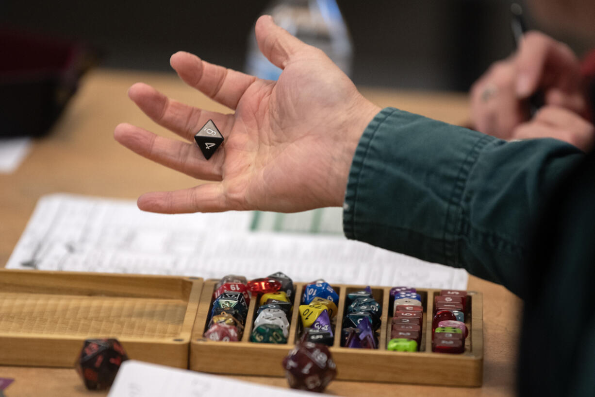 Secretary of State Steve Hobbs takes a turn while playing Dungeons &amp; Dragons at the Camas Public Library on Monday afternoon. The role-playing game kit was donated through the Washington State Library, which his office oversees.