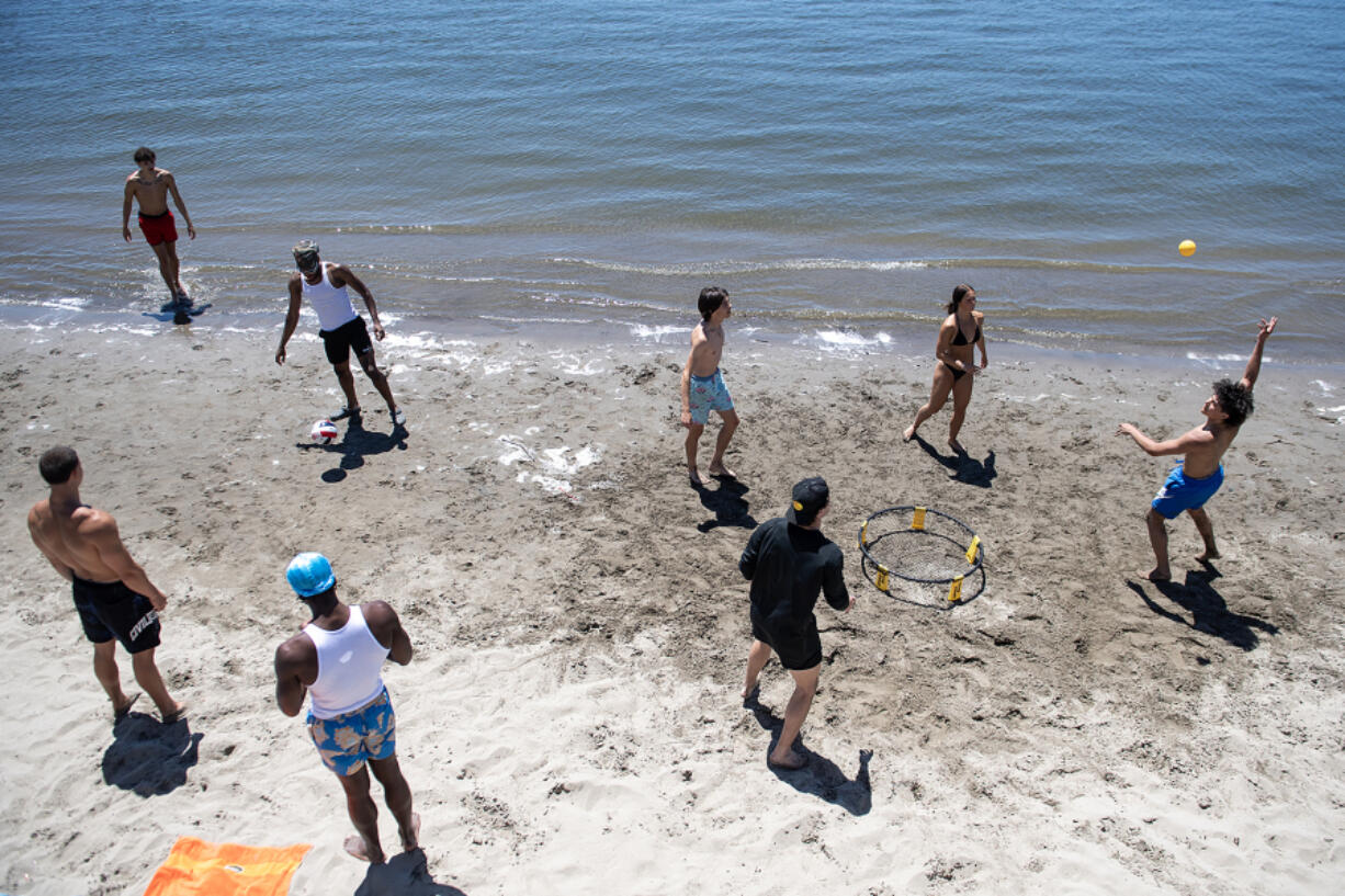 Blue skies and sunshine drew warm weather enthusiasts to the shoreline along the Columbia River near Columbia Shores Condominiums on Thursday afternoon. Forecasters predict the warm weather will stick around through the weekend.