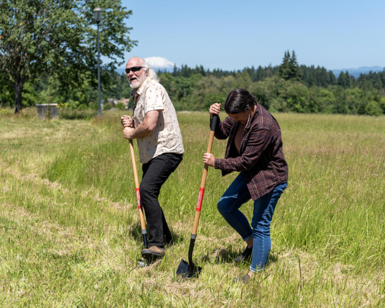 At right, Cheyenne and Lakota artist and activist Roben White and Portland State University Indigenous traditional ecological and cultural knowledge coordinator Emma Johnson stick shovels in the ground Wednesday during a ceremonial groundbreaking for a new Indigenous Traditional Ecological Knowledge Garden at Washington State University Vancouver. The garden is intended to link education in agriculture with lessons in the history of Southwest Washington.