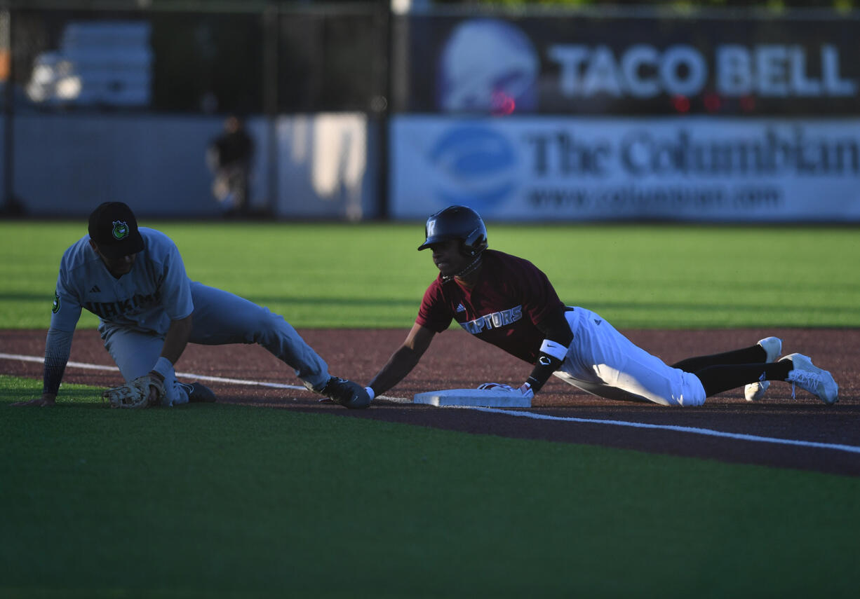 Ridgefield's Dasan Harris, right, steals third base from Yakima Valley's Julian Angulo on Tuesday June 11, 2024, during the Raptors’ 10-0 win against Yakima Valley Pippins at the Ridgefield Outdoor Recreation Complex.