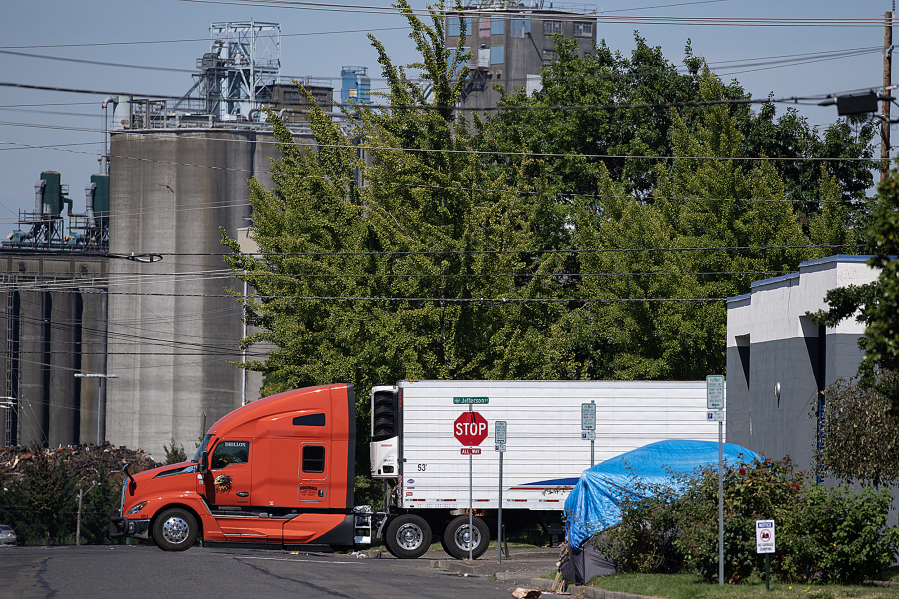 A truck passes a tent along West 11th Street in downtown Vancouver. A bridge shelter will help address unsheltered homelessness in Vancouver, city staff say.