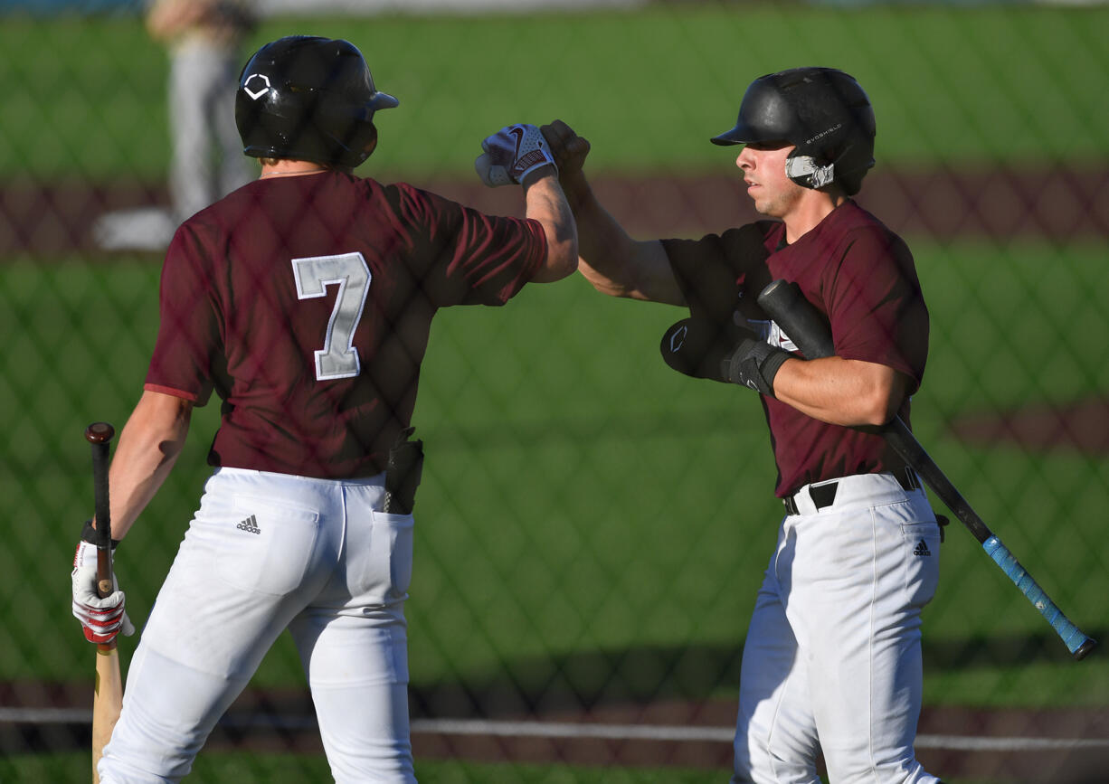 Ridgefield's Patrick Engskov (7) celebrates with Luke Iverson after Iverson scored a run Thursday, July 27, 2024, during a game between the Raptors and the Bend Elks at the Ridgefield Outdoor Recreation Complex.