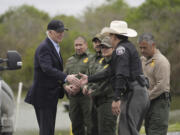 FILE - President Joe Biden talks with the U.S. Border Patrol and local officials, as he looks over the southern border, Feb. 29, 2024, in Brownsville, Texas, along the Rio Grande. Biden's migration order aims to shut down asylum requests at US-Mexico border if illegal crossings average 2,500 per day.