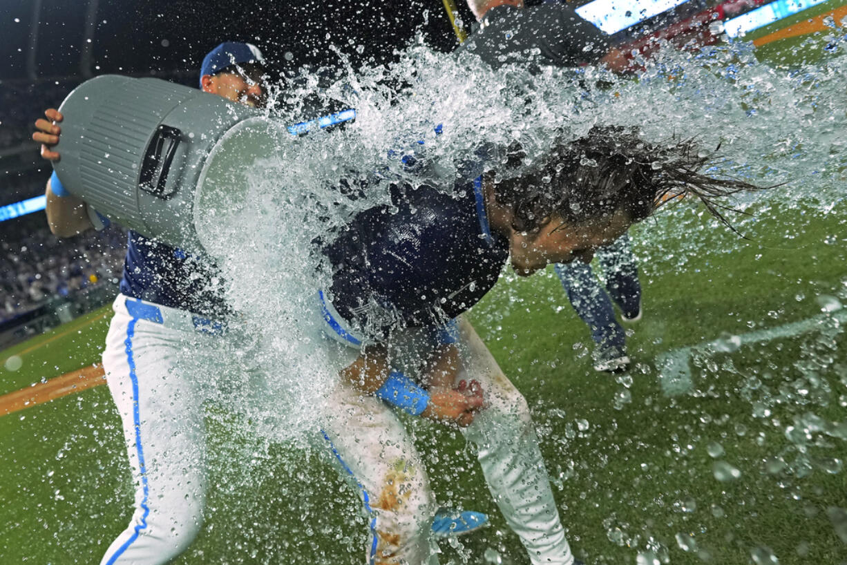 Kansas City Royals' Bobby Witt Jr., right, is doused by Vinnie Pasquantino after their baseball game against the Seattle Mariners Friday, June 7, 2024, in Kansas City, Mo. The Royals won 10-9.