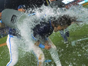 Kansas City Royals' Bobby Witt Jr., right, is doused by Vinnie Pasquantino after their baseball game against the Seattle Mariners Friday, June 7, 2024, in Kansas City, Mo. The Royals won 10-9.