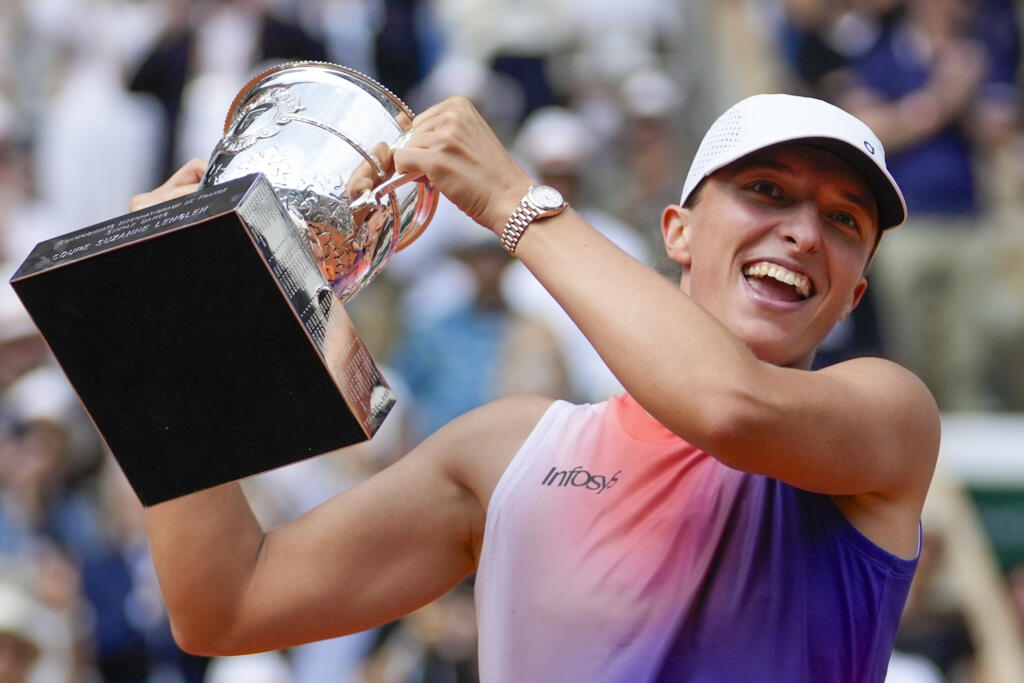 Poland's Iga Swiatek holds the trophy after winning the women's final of the French Open tennis tournament against Italy's Jasmine Paolini at the Roland Garros stadium in Paris, France, Saturday, June 8, 2024.