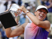 Poland's Iga Swiatek holds the trophy after winning the women's final of the French Open tennis tournament against Italy's Jasmine Paolini at the Roland Garros stadium in Paris, France, Saturday, June 8, 2024.