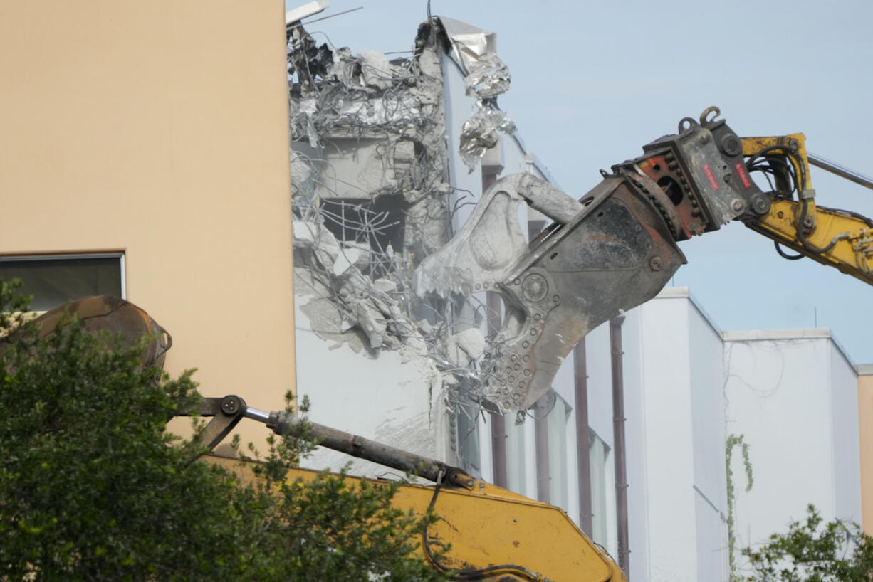 Crews start the demolition of the Marjory Stoneman Douglas High School building, Friday, June 14, 2024, where 17 people died in the 2018 mass shooting in Parkland, Fla. Officials plan to complete the weekslong project before the school's 3,300 students return in August from summer vacation.