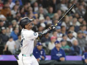 Seattle Mariners' Julio Rodríguez watches his two-run home run off Texas Rangers starting pitcher Nathan Eovaldi during the third inning of a baseball game Saturday, June 15, 2024, in Seattle.