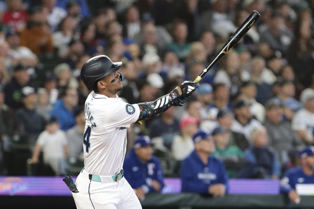 Seattle Mariners' Julio Rodríguez watches his two-run home run off Texas Rangers starting pitcher Nathan Eovaldi during the third inning of a baseball game Saturday, June 15, 2024, in Seattle.