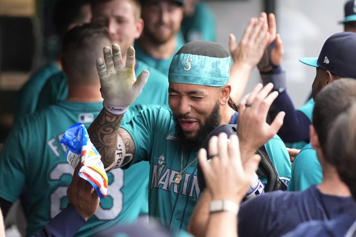 Seattle Mariners' J.P. Crawford celebrates in the dugout after his home run against the Cleveland Guardians during the third inning of a baseball game Tuesday, June 18, 2024, in Cleveland.