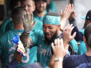 Seattle Mariners' J.P. Crawford celebrates in the dugout after his home run against the Cleveland Guardians during the third inning of a baseball game Tuesday, June 18, 2024, in Cleveland.