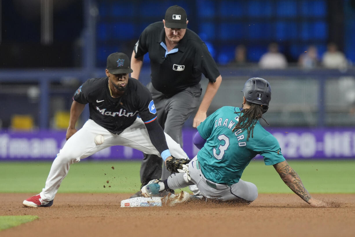 Seattle Mariners' J.P. Crawford (3) steals second base as Miami Marlins second baseman Otto Lopez drops the ball during the first inning of a baseball game against the Miami Marlins, Friday, June 21, 2024, in Miami.