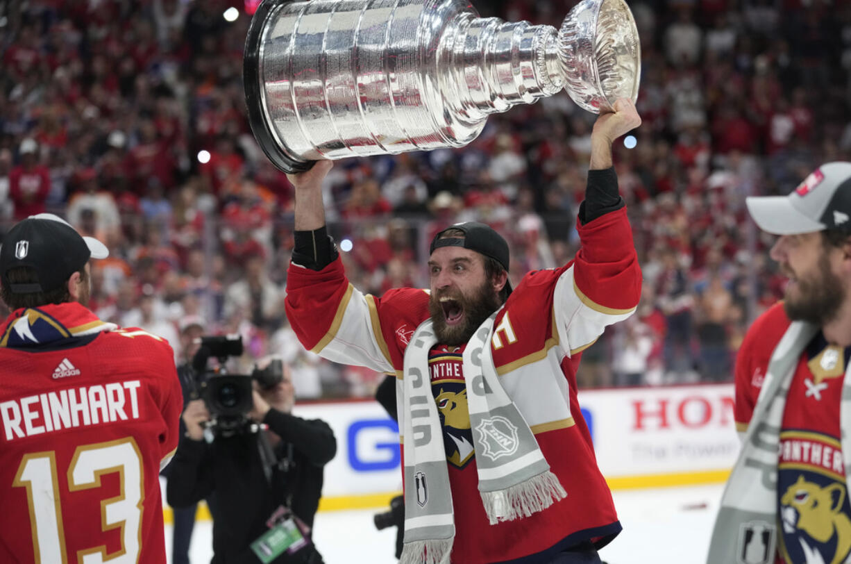 Florida Panthers defenseman Aaron Ekblad raises the NHL hockey Stanley Cup trophy after defeating the Edmonton Oilers in Game 7 of the Final, Monday, June 24, 2024, in Sunrise, Fla.