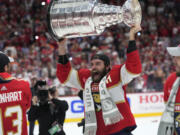 Florida Panthers defenseman Aaron Ekblad raises the NHL hockey Stanley Cup trophy after defeating the Edmonton Oilers in Game 7 of the Final, Monday, June 24, 2024, in Sunrise, Fla.