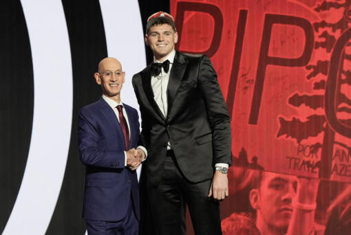 Donovan Clingan, right, poses for a photo with NBA commissioner Adam Silver after being selected by the Portland Trail Blazers as the seventh pick during the first round of the NBA basketball draft, Wednesday, June 26, 2024, in New York. (AP Photo/Julia Nikhinson)