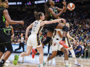 Indiana Fever's Caitlin Clark (22) punches the ball out of the hands of Seattle Storm's Ezi Magbegor during the first half of a WNBA basketball game Thursday, June 27, 2024, in Seattle.