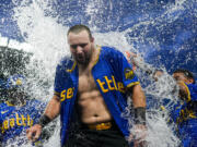 Seattle Mariners' Cal Raleigh is doused by teammates after hitting a ground ball to drive in the winning run in the 10th inning against the Minnesota Twins in a baseball game Friday, June 28, 2024, in Seattle. The Mariners won 3-2.