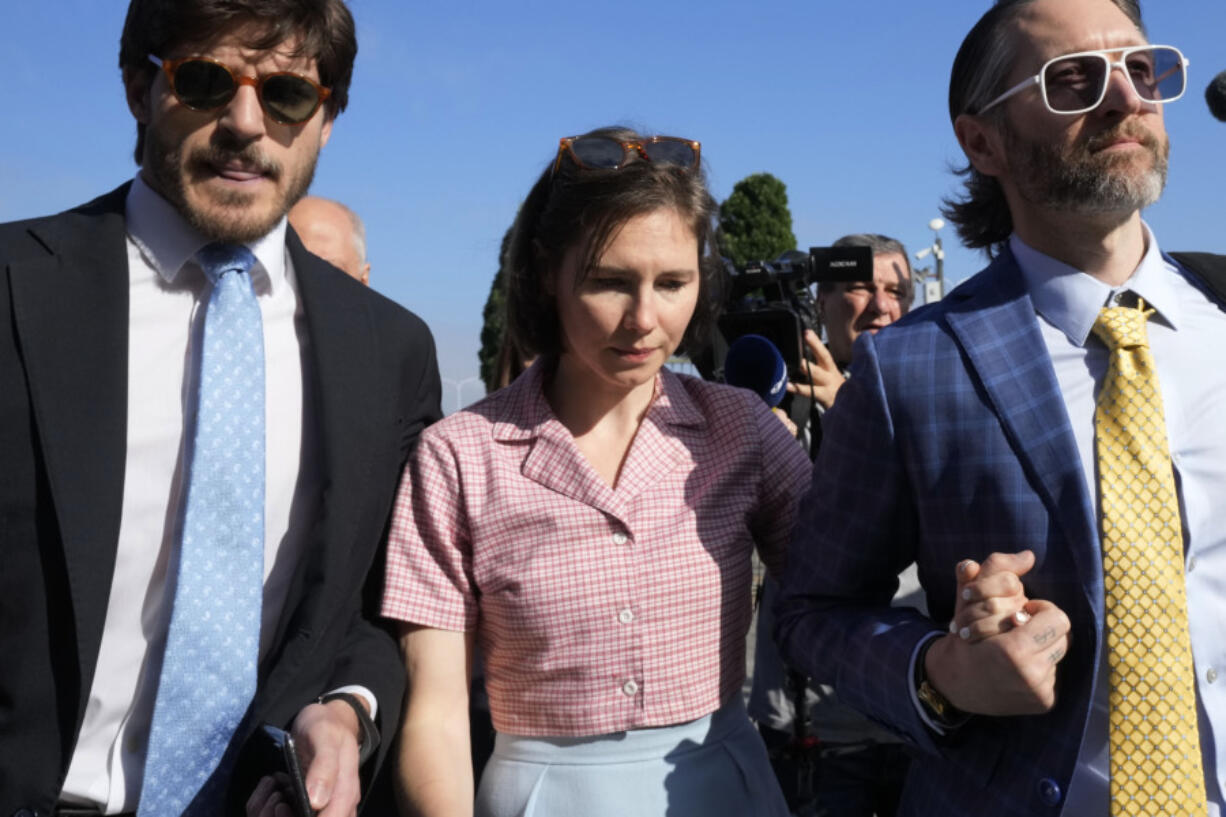 Amanda Knox arrives flanked by her husband Christopher Robinson, right, at the Florence courtroom in Florence, Italy, Wednesday, June 5, 2024. Amanda Knox returns to an Italian courtroom Wednesday for the first time in more than 12&frac12; years to clear herself &ldquo;once and for all&rdquo; of a slander charge that stuck even after she was exonerated in the brutal 2007 murder of her British roommate in the idyllic hilltop town of Perugia.