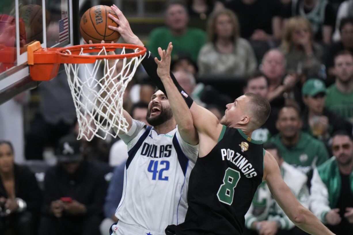 Boston Celtics center Kristaps Porzingis (8) blocks a shot by Dallas Mavericks forward Maxi Kleber (42) during the first half of Game 2 of the NBA Finals basketball series, Sunday, June 9, 2024, in Boston.