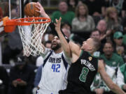 Boston Celtics center Kristaps Porzingis (8) blocks a shot by Dallas Mavericks forward Maxi Kleber (42) during the first half of Game 2 of the NBA Finals basketball series, Sunday, June 9, 2024, in Boston.