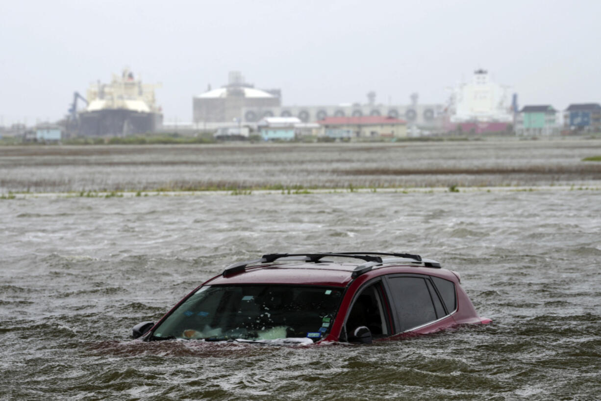 A car sits submerged in water as Tropical Storm Alberto approaches land Wednesday, June 19, 2024, in Surfside Beach, Texas.