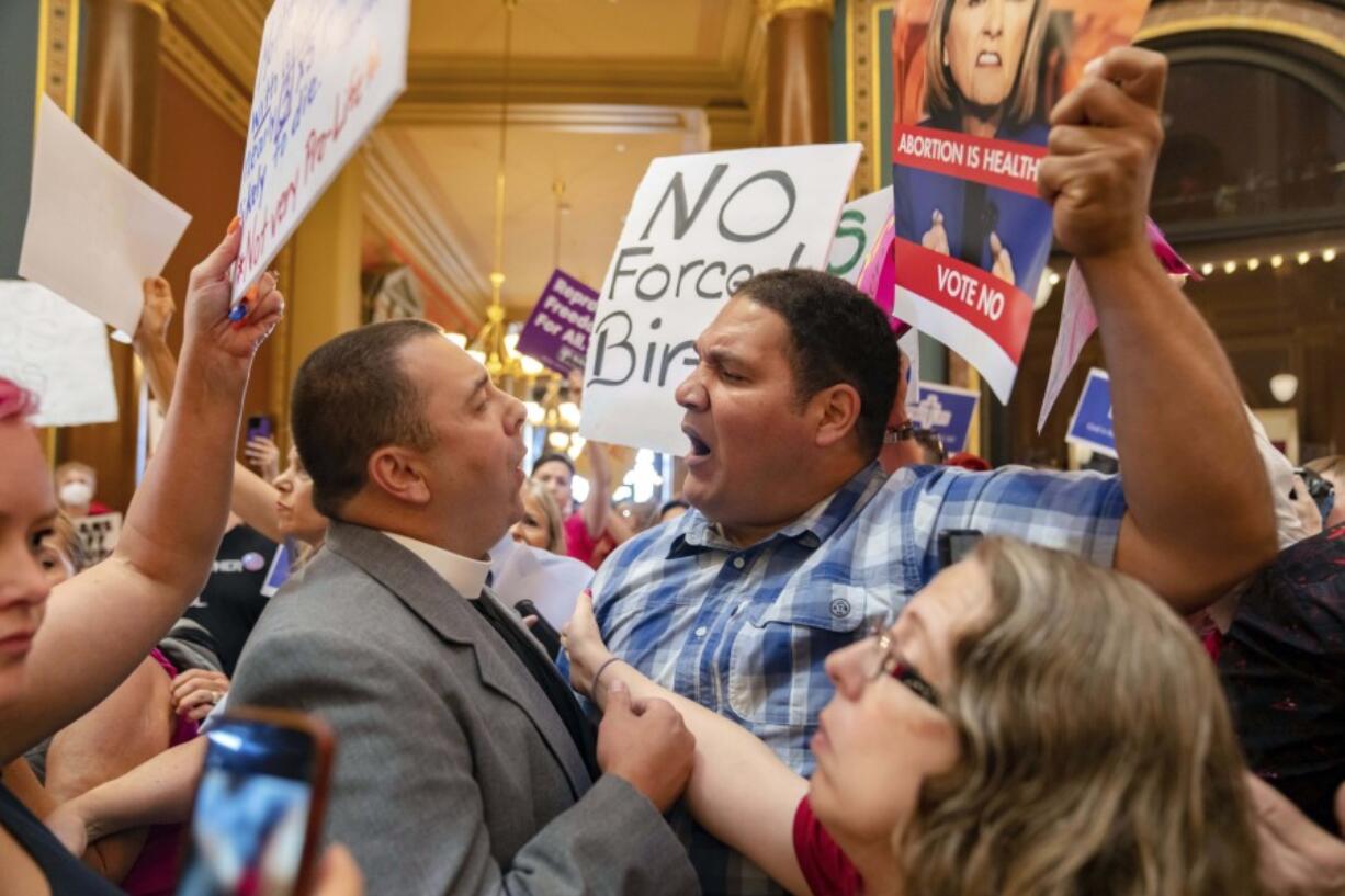 FILE - Pastor Michael Shover of Christ the Redeemer Church in Pella, left, argues with Ryan Maher, of Des Moines, as protestors voice opposition to a new ban on abortion after roughly six weeks of pregnancy introduced by Republican lawmakers in a special session in Des Moines, Iowa, July 11, 2023. The Iowa Supreme Court is expected to weigh in on the state&rsquo;s temporarily blocked abortion law, which prohibits abortions after about six weeks of pregnancy and before many women know they are pregnant on Friday, June 27, 2024.