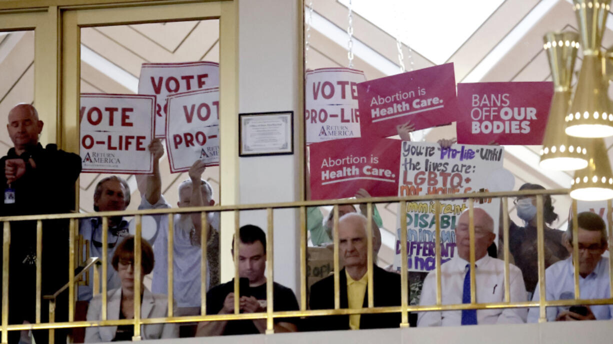 FILE - Protesters on both sides of the issue hold signs as North Carolina House members debate, May 16, 2023, in Raleigh, N.C. On Monday, June 3, 2024, a federal judge permanently blocked some efforts in North Carolina to restrict how abortion pills can be dispensed, saying they are unlawfully in conflict with the authority of the U.S. Food and Drug Administration. But she allowed other state laws to remain in effect, granting only a partial victory to a doctor who sued.