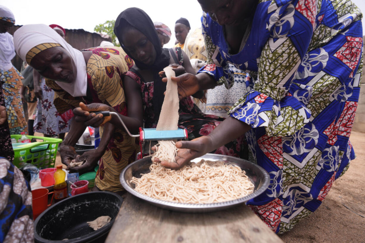 Women learn how to prepare Spaghetti that will boost their families&rsquo; nutrient intake with orange-fleshed sweet potato, in Kaltungo Poshereng Nigeria, Sunday, June 2, 2024. More than a dozen women gathered this week in Kaltungo&rsquo;s Poshereng village where they are learning at least 200 recipes they can prepare with those local foods which, in the absence of rain, are grown in sand-filled sacks that require small amounts of water. The training session mirrored the struggles of households who are more challenged amid Nigeria&rsquo;s worst cost of living crisis.