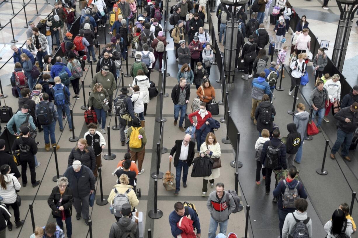 FILE - Passengers wait in a security line at Denver International Airport on Wednesday, Feb. 22, 2023. The TSA expects to break the 3 million mark on Friday, as many Americans get an early start on their July 4 travel plans. It&rsquo;s just the start of what promises to be a busy summer.