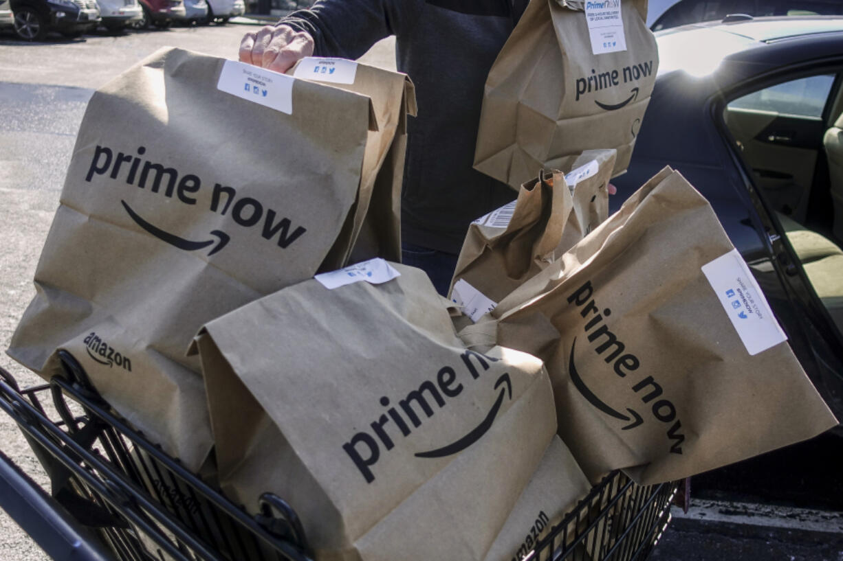 FILE - Amazon Prime Now bags are loaded for delivery outside a Whole Foods store on Feb. 8, 2018, in Cincinnati. Thousands of delivery drivers filed legal claims against Amazon on Tuesday, June 11, 2024, alleging the company&#039;s classification of them as independent contractors instead of employees has led to unpaid wages and other types of financial loss.