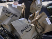 FILE - Amazon Prime Now bags are loaded for delivery outside a Whole Foods store on Feb. 8, 2018, in Cincinnati. Thousands of delivery drivers filed legal claims against Amazon on Tuesday, June 11, 2024, alleging the company&#039;s classification of them as independent contractors instead of employees has led to unpaid wages and other types of financial loss.