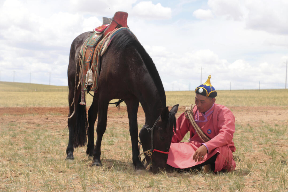 A herder sits with his horse on an open plain in Inner Mongolia, China, July 2019. Scientists analyzed ancient horse genomes to calculate dates for the domestication of the modern horse -- 4,200 years ago, according to new research published Thursday, June 6, 2024,  in the journal Nature.