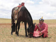 A herder sits with his horse on an open plain in Inner Mongolia, China, July 2019. Scientists analyzed ancient horse genomes to calculate dates for the domestication of the modern horse -- 4,200 years ago, according to new research published Thursday, June 6, 2024,  in the journal Nature.