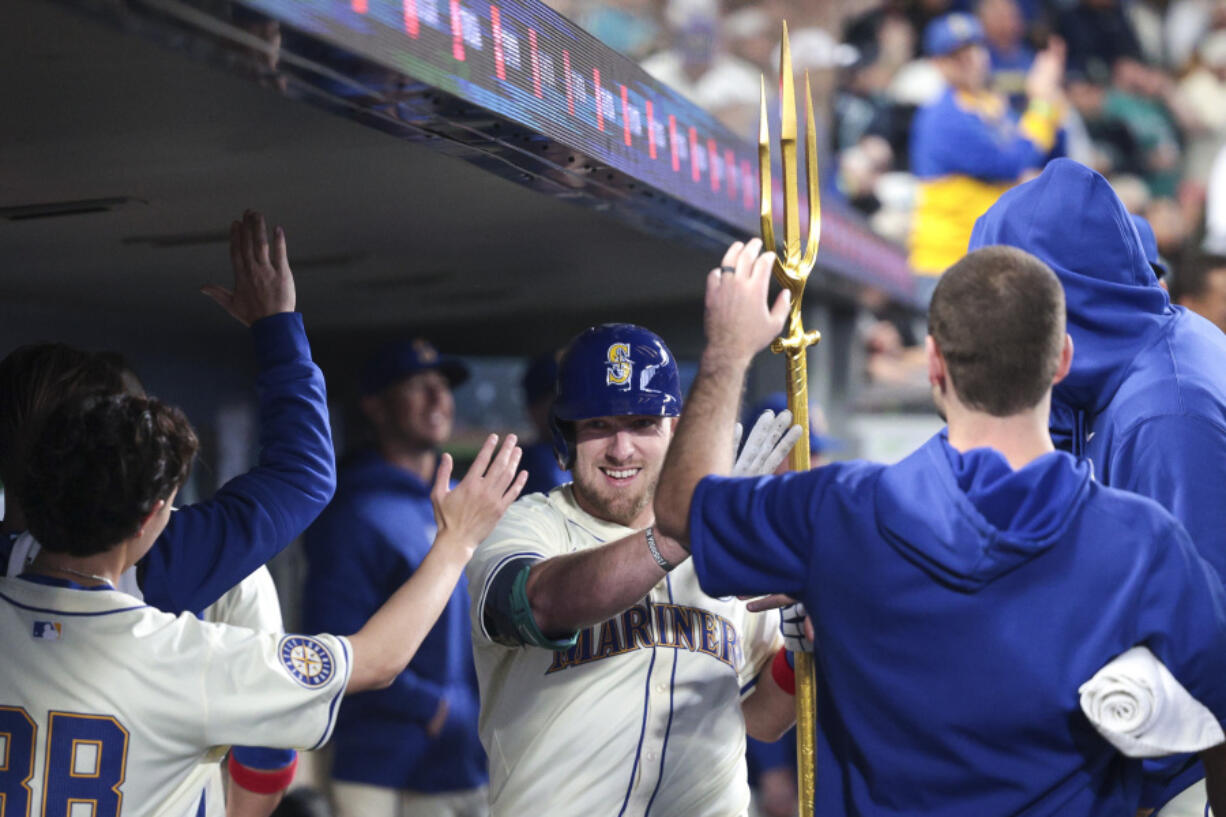 Seattle Mariners&#039; Luke Raley, center, celebrates in the dugout after hitting a home run off Los Angeles Angels starting pitcher Griffin Canning during the fourth inning of a baseball game, Sunday, June 2, 2024, in Seattle.