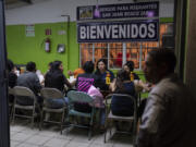 Female migrants, mostly Mexican nationals recently deported from the U.S., eat their dinner at the San Juan Bosco migrant shelter in Nogales, Mexico, Tuesday, June 25, 2024. Many migrants who fail interviews are deported to Nogales, a sprawling city in the Mexican state of Sonora, and end up at the shelter, where a giant fan in a former chapel offers relief from blistering summer heat. (AP Photo/Jae C.