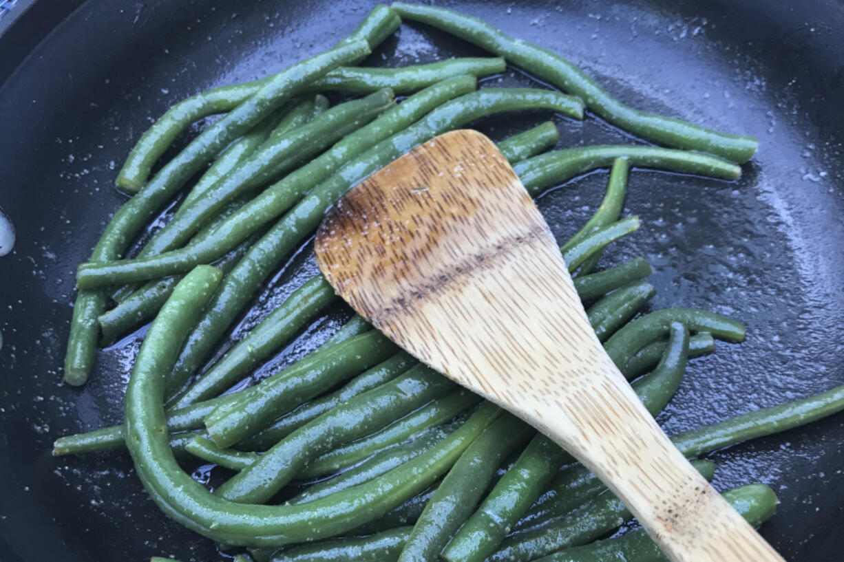 Green beans picked from a home garden are cooked in a saute pan in Chatham, Mass. Nutrition experts say you can improve your health by eating whatever fruits and vegetables are in season.