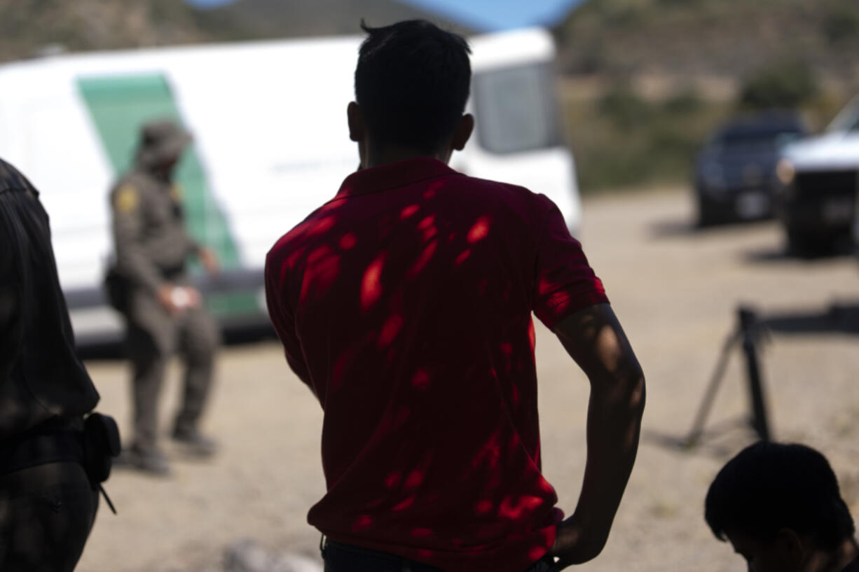 Migrant men from Mexico seeking asylum wait to be transported and processed, Wednesday, June 5, 2024, near Dulzura, Calif. President Joe Biden on Tuesday unveiled plans to enact immediate significant restrictions on migrants seeking asylum at the U.S.-Mexico border as the White House tries to neutralize immigration as a political liability ahead of the November elections.