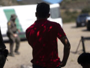 Migrant men from Mexico seeking asylum wait to be transported and processed, Wednesday, June 5, 2024, near Dulzura, Calif. President Joe Biden on Tuesday unveiled plans to enact immediate significant restrictions on migrants seeking asylum at the U.S.-Mexico border as the White House tries to neutralize immigration as a political liability ahead of the November elections.