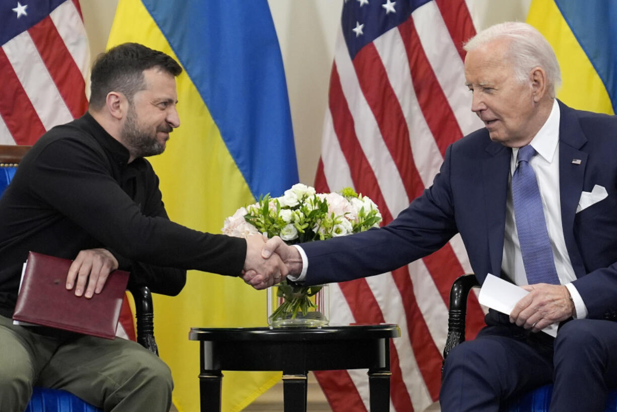 U.S. President Joe Biden shakes hands with Ukrainian President Volodymyr Zelenskyy in Paris, Friday, June 7, 2024.