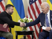 U.S. President Joe Biden shakes hands with Ukrainian President Volodymyr Zelenskyy in Paris, Friday, June 7, 2024.