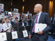 Boeing CEO Dave Calhoun looks at protesters and families of victims as he arrives to testify before the Senate Homeland Security and Governmental Affairs Subcommittee on Investigations to answer to lawmakers about troubles at the aircraft manufacturer since a panel blew out of a Boeing 737 Max during an Alaska Airlines flight in January, at the Capitol in Washington, Tuesday, June 18, 2024.