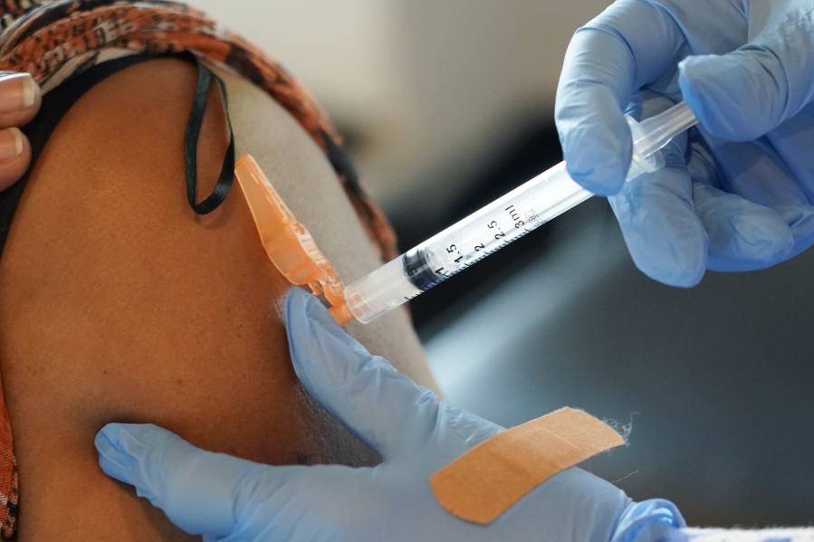 Jackson-Hinds Comprehensive Health Center nurse Maggie Bass, right, gives a COVID-19 vaccine to an unidentified person, Sept. 21, 2021, in Jackson, Miss.